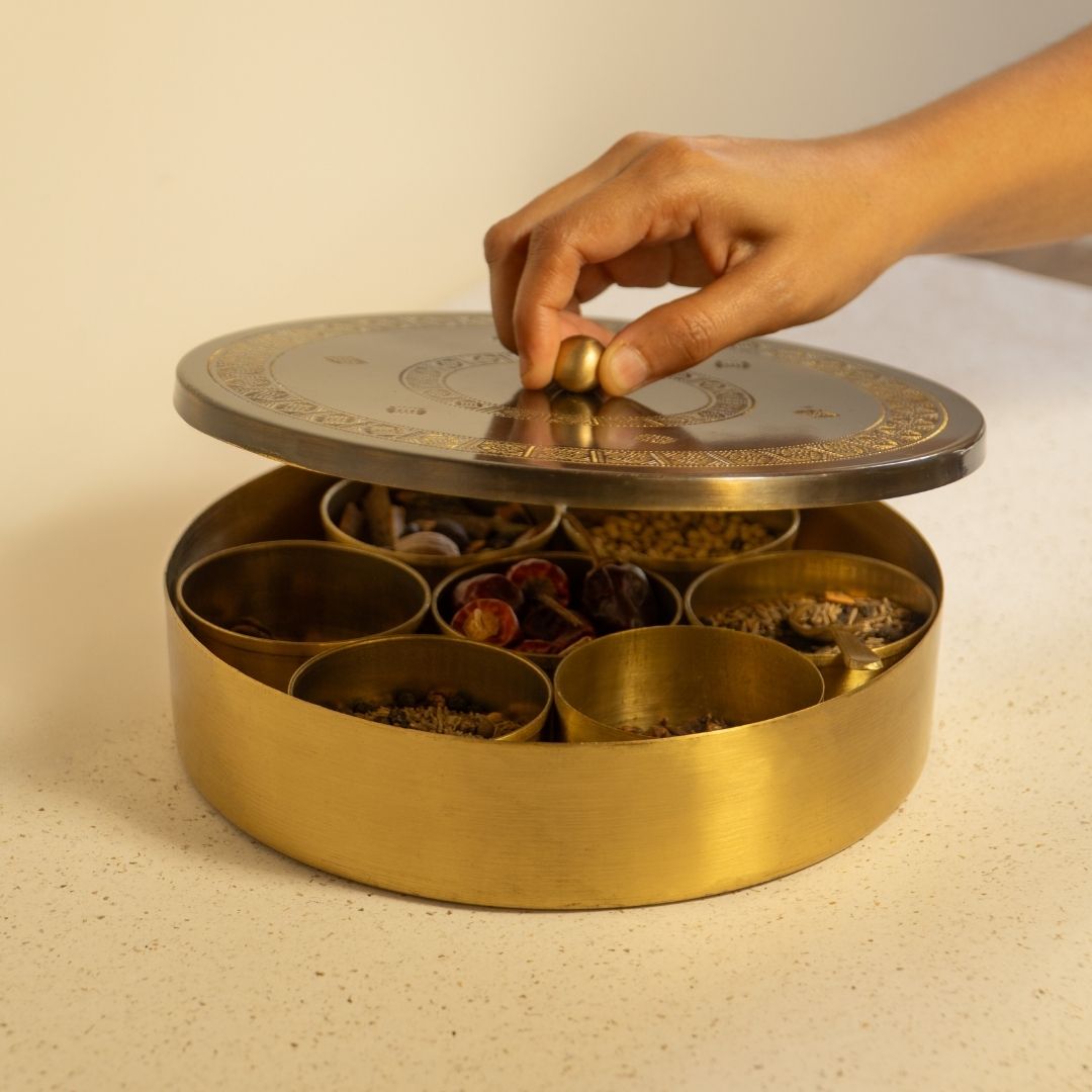 Kitchen masala box or spice box made with Pure Brass in an Antique Kanjeevaram Design. The masala box comes with 7 detachable containers and spoon