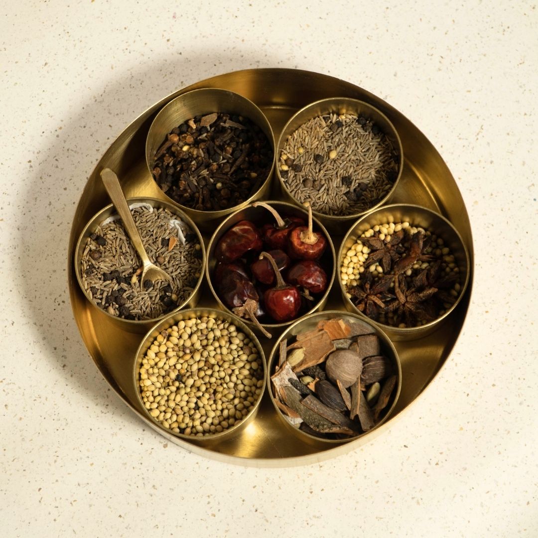 Kitchen masala box or spice box made with Pure Brass in an Antique Kanjeevaram Design. The masala box comes with 7 detachable containers and spoon