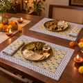 Mustard Floral Placemat and Napkin Set of 12, set for a Diwali meal with brass thalis and diyas