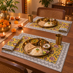 Mustard Floral Chevron Border Placemat and Napkin Set of 12, set for a Diwali meal with brass thalis and diyas