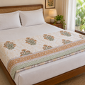 Tan and Olive Floral Dohar, folded at the foot of a made bed