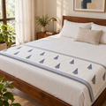 Navy Tree Motif Dohar, folded at the foot of a made bed