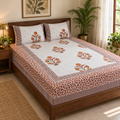 Rust Floral Buta Bedsheet Set, on a made double bed in a bright bedroom